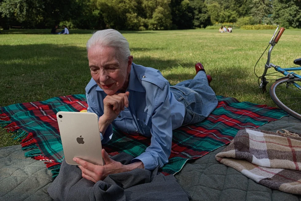 Person using iPad mini on blanket outdoors